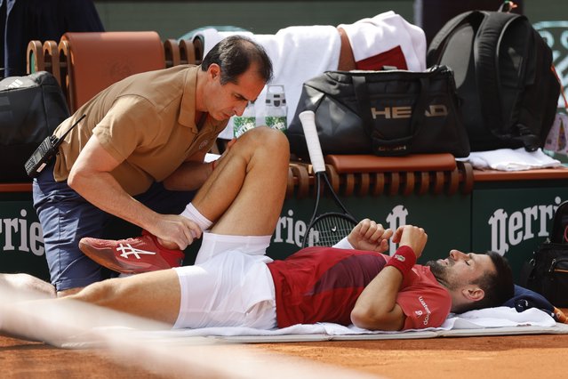 Serbia's Novak Djokovic receives medical assistance for his right knee during his fourth round match of the French Open tennis tournament against Argentina's Francisco Cerundolo at the Roland Garros stadium in Paris, Monday, June 3, 2024. Novak Djokovic withdrew from the French Open with an injured right knee on Tuesday, June 4, 2024, ending his title defense and meaning he will relinquish the No. 1 ranking. (Photo by Jean-Francois Badias/AP Photo)
