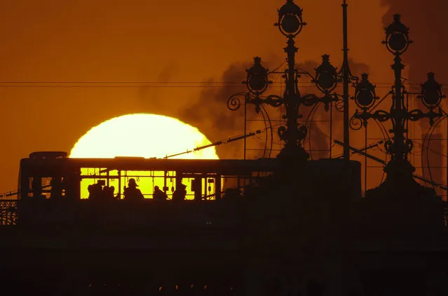 People ride a bus at sunset in St.Petersburg, Russia, Tuesday, February 7, 2017. (Photo by Dmitri Lovetsky/AP Photo)