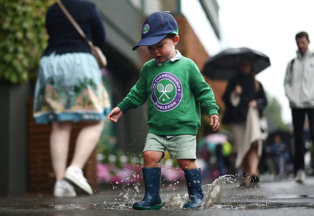 A young spectator jumps in a puddle in the grounds as rain suspends play on the outside courts during day five of The Championships Wimbledon 2024 at All England Lawn Tennis and Croquet Club on July 05, 2024 in London, England. (Photo by Francois Nel/Getty Images)