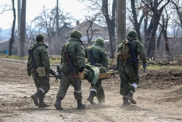 Service members of pro-Russian troops carry a body of a serviceman killed in fighting in the Ukraine-Russia conflict in the city of Mariupol, Ukraine on March 31, 2022. (Photo by Chingis Kondarov/Reuters)