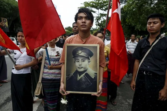 People hold General Aung San's portrait as they wait to pay respect during an event marking the anniversary of Martyrs' Day outside the Martyrs' Mausoleum in Yangon July 19, 2015. Myanmar celebrates the 68th anniversary of Martyr's Day on Sunday to commemorate the assassination of the fallen independence heroes, including General Aung San, one of the most revered figures and the father of Myanmar's pro-democracy leader Aung San Suu Kyi. (Photo by Soe Zeya Tun/Reuters)