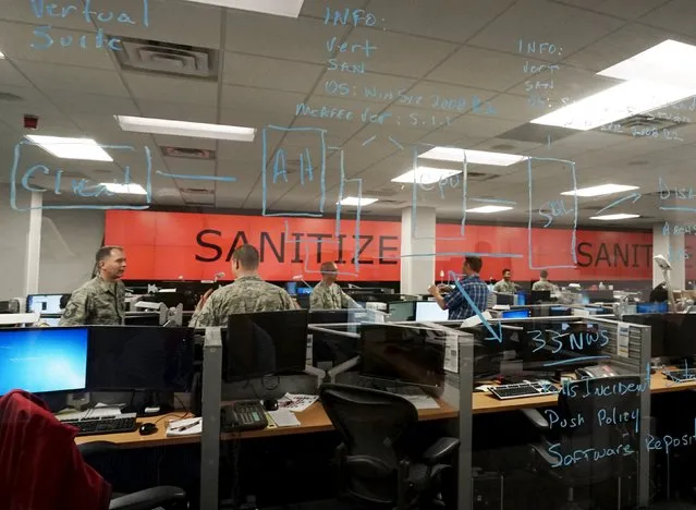 U.S. Air Force and civilian personnel seen through a window work at the 561st Network Operations Squadron (NOS) at Petersen Air Force Base in Colorado Springs, Colorado July 20, 2015. (Photo by Rick Wilking/Reuters)