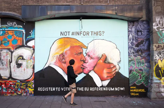 A man passes a mural that has been painted on a derelict building in Stokes Croft showing US presidential hopeful Donald Trump sharing a kiss with former London Mayor Boris Johnson on May 24, 2016 in Bristol, England. Boris Johnson is currently one of the biggest names leading the campaign for Britain to leave the European Union in the referendum which takes place on June 23 and Republican presidential hopeful Donald Trump has also backed a so-called Brexit. (Photo by Matt Cardy/Getty Images)