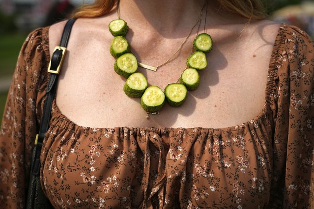 A woman wears a necklace made of cucumbers during Cucumber Day in the Russian ancient city of Suzdal, some 200 km (124 miles) east of Moscow, Russia, Saturday, July 13, 2024. For almost two decades, Cucumber Day is celebrated in Suzdal in the middle of July, the best time for harvesting the vegetable. The idea to celebrate it came from the employees of the Vladimir-Suzdal Museum-Reserve to reflect historic traditions of vegetable growing in the Suzdal region. (Photo by Pavel Bednyakov/AP Photo)