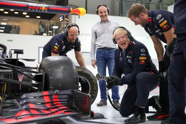 Britain's Prime Minister Boris Johnson changes a wheel in a Formula One car during his visit at Red Bull Racing in Milton Keynes, Britain on December 4, 2019. (Photo by Hannah McKay/Pool via Reuters)