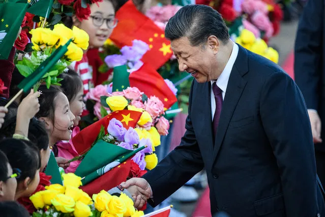 China's President Xi Jinping (R) shakes hands with a girl as she and other children welcome Xi upon his arrival at Macau's international airport in Macau on December 18, 2019, ahead of celebrations for the 20th anniversary of the handover from Portugal to China. Chinese president Xi Jinping landed in Macau on December 18 as the city prepares to mark 20 years since the former Portuguese colony was returned, a celebration that stands in stark contrast to months of unrest in neighbouring Hong Kong. (Photo by Anthony Wallace/AFP Photo)