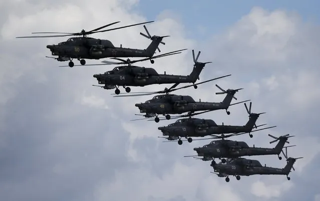 Russian Mi-28N from the Berkuty (Golden Eagles) helicopter display team fly in formation during the “Aviadarts” military aviation competition at the Dubrovichi range near Ryazan, Russia, August 2, 2015. (Photo by Maxim Shemetov/Reuters)