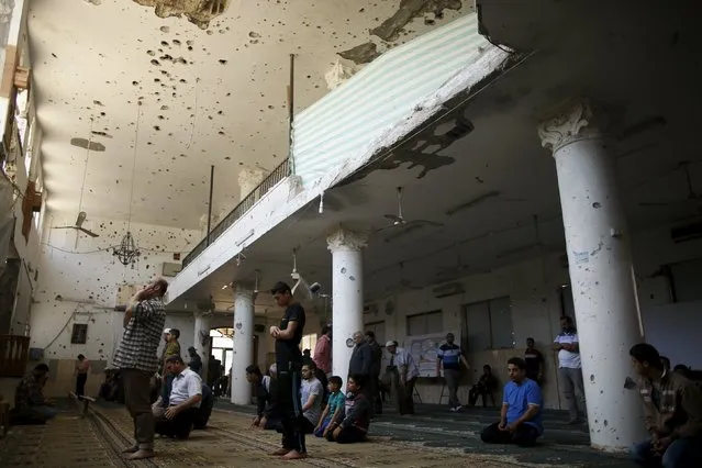 Palestinians pray inside a mosque that witnesses said was badly damaged by Israeli shelling during a 50-day war last summer, in the east of Gaza City May 6, 2015. (Photo by Mohammed Salem/Reuters)