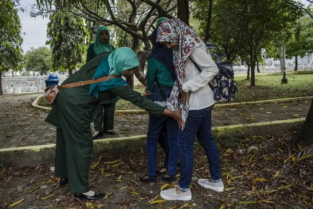 Members of the sharia police women known as Wilayatul Hisbah stop teenage girls who are wearing tights which goes against the prevailing sharia law on March 21, 2017 in Banda Aceh,  Indonesia. Indonesia's Aceh Province, on the northern tip of Sumatra island, is among the only place in the Muslim-majority country which implements the strict version of Sharia Law. Public canings take place regularly in Aceh for a range of offenses from adultery to homosexuality to selling alcohol, while women are required to dress modestly and Shariah police officers patrol the streets and conduct raids to hunt for immoral activities. More than 90 per cent of the 255 million people who live in Indonesia describe themselves as Muslim,  but the vast majority practice a moderate form. According to reports, the Shariah Law in Aceh began in 2001, after receiving authorization from Indonesia's central government, which was intent on calming separatist sentiment in the conservative region while today. (Photo by Ulet Ifansasti/Getty Images)