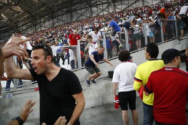 Football Soccer, England vs Russia, EURO 2016, Group B, Stade Vélodrome, Marseille, France on June 11, 2016. England fans climb over a fence to escape trouble in the stadium after the game. (Photo by Kai Pfaffenbach/Reuters/Livepic)
