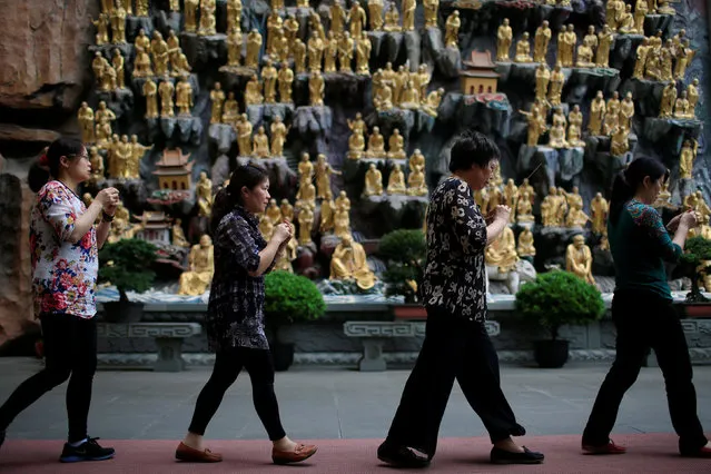 Families participate at a ceremony to pray for the students taking China's annual National College Entrance Exam which finishes today at Donglin Temple in Shanghai, China June 8, 2016. (Photo by Aly Song/Reuters)