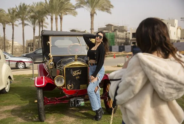 Classic cars enthusiast Carine Sherif poses in front of a 1924 Ford T owned by Egyptian collector Mohamed Wahdan during a classic car show in Cairo, Egypt, Saturday, March 19, 2022. (Photo by Amr Nabil/AP Photo)