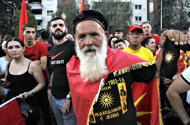 A protester wearing a shirt, reading in Macedonian “Macedonia is alive” attends a protest in front of the government building in Skopje, North Macedonia, on Saturday, July 2, 2022. Tens of thousands of people have gathered late on Saturday in North Macedonia's capital Skopje to protest the latest French presidency proposal on solving bilateral disputes with Bulgaria that gave directions for small Balkan country to open membership talks with the European Union. (Photo by Boris Grdanoski/AP Photo)