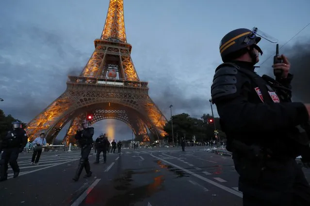 French CRS riot police hold a position during clashes near the Eiffel Tower at the Paris fan zone during the Portugal vs France EURO 2016 final soccer match in Paris, France, July 10, 2016. French police fired tear gas to disperse dozens of people trying to enter the “fan zone” at the foot of the Eiffel Tower to watch the final of the Euro 2016 soccer tournament on Sunday evening, to prevent overcrowding. (Photo by Philippe Wojazer/Reuters)