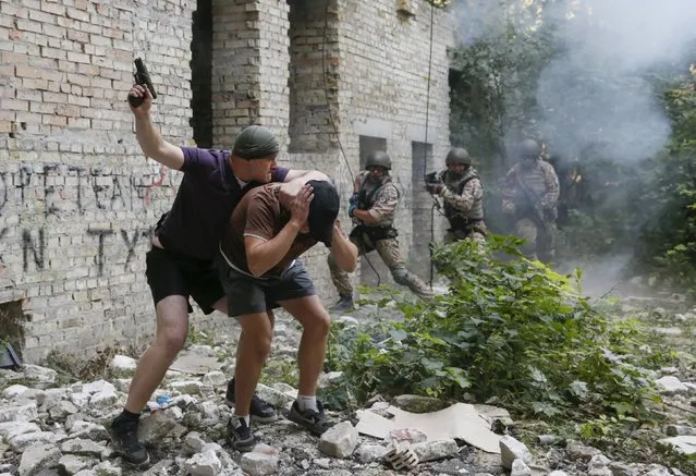 Members of the Ukrainian Interior Ministry's special battalion Kiev-1 rescue a hostage, who was detained by a mock terroist, during an anti-terror drill in Kiev, Ukraine, August 28, 2015. (Photo by Valentyn Ogirenko/Reuters)