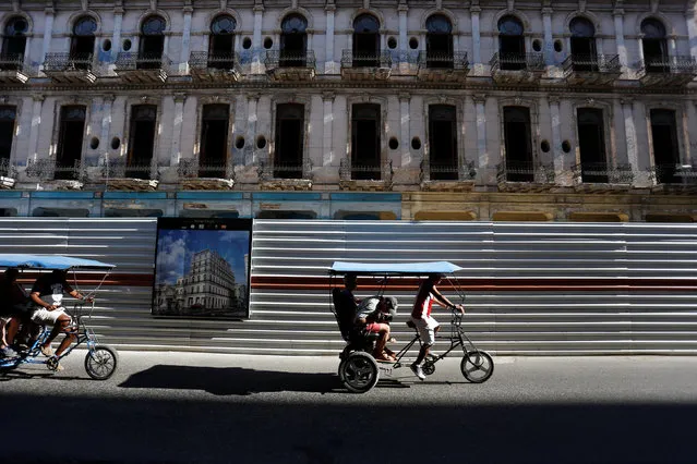 Pedicabs drive past a historic building undergoing restoration work to become a hotel, as the Cuban government works with foreign companies to add hotel rooms to the island by the end of the year, in Havana, Cuba March 28, 2017. (Photo by Reuters/Stringer)