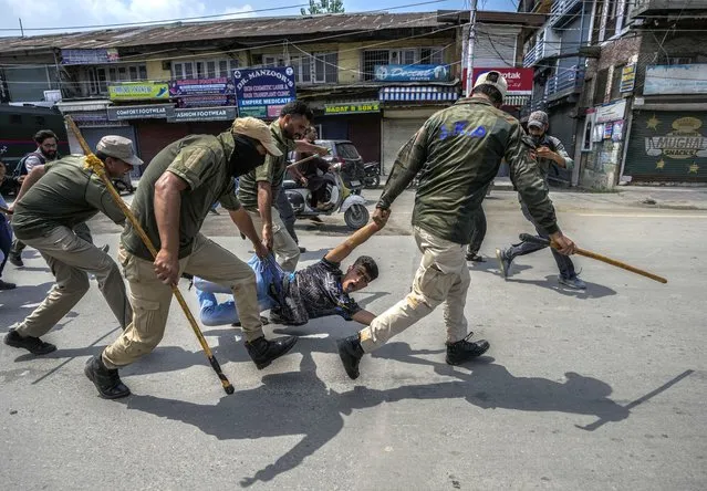 Indian policemen detain a Kashmiri Shiite Muslim for participating in a religious procession during restrictions in Srinagar, Indian controlled Kashmir, Sunday, August 7, 2022. Authorities had imposed restrictions in parts of Srinagar, the region's main city, to prevent gatherings marking Muharram from developing into anti-India protests. (Photo by Mukhtar Khan/AP Photo)