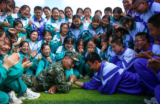 An instructor and a high school freshman arm wrestle during a military training on August 10, 2022 in Jiuquan, Gansu Province of China. (Photo by Hou Chonghui/VCG via Getty Images)