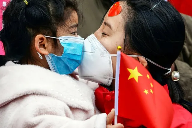 A medical staff member kisses her daughter after returning home from Wuhan helping with the COVID-19 coronavirus recovery effort, in Bozhou, in China's eastern Anhui province on April 10, 2020. (Photo by AFP Photo/China Stringer Network)