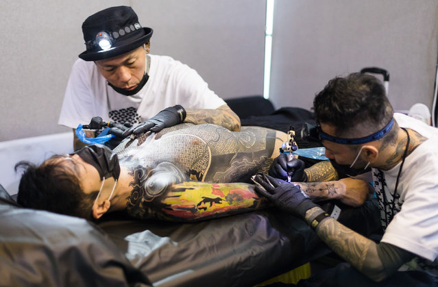 Tattoo artists works on a man's tattoo during the London Tattoo Convention at the Tobacco Docks, in London, Britain, 24 September 2017. (Photo by Vickie Flores/Rex Features/Shutterstock)