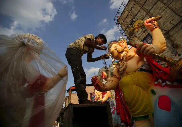 An artisan works on an idol of Hindu elephant god Ganesh, the deity of prosperity, at a roadside workshop in New Delhi, India, August 31, 2015. (Photo by Anindito Mukherjee/Reuters)