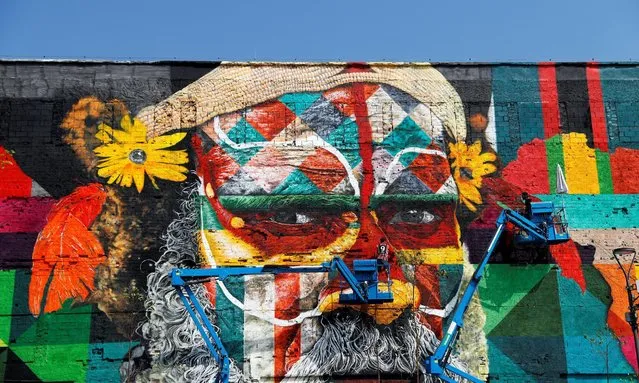 Painters work on a mural created by Brazilian artist Eduardo Kobra that when finished will cover nearly 3,000 square meters of wall space and depict indigenous faces from five continents, to welcome visitors to the Rio 2016 Olympic Games, in Rio de Janeiro July 25, 2016. (Photo by Stoyan Nenov/Reuters)
