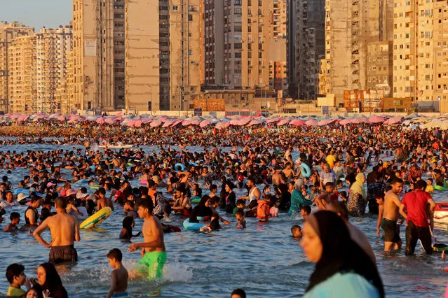 People swim along the beach on the Mediterranean Sea on July 29, 2022 in Alexandria, Egypt. Vacationers come from all over the Arab Republic of Egypt during the summer to stroll in the city of Alexandria to enjoy the salty waters of the Mediterranean Sea. (Photo by Fadel Dawod/Getty Images)