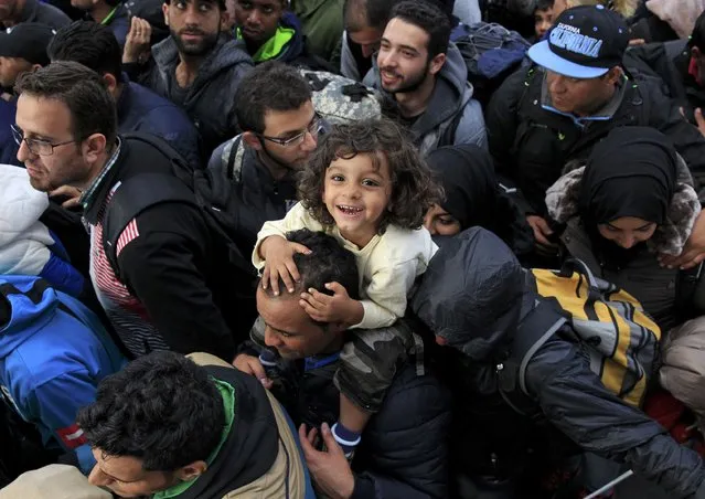 A migrant baby reacts as others queue to board a train at Keleti station in Budapest, Hungary September 10, 2015. (Photo by Bernadett Szabo/Reuters)