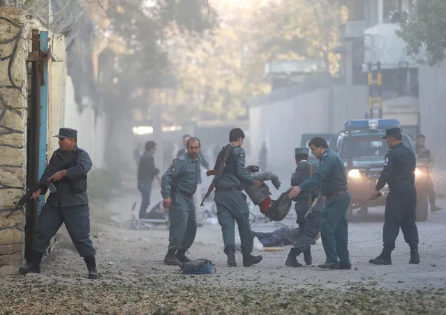 Afghan policemen carry an injuried after a blast in Kabul, Afghanistan on October 31, 2017. (Photo by Mohammad Ismail/Reuters)
