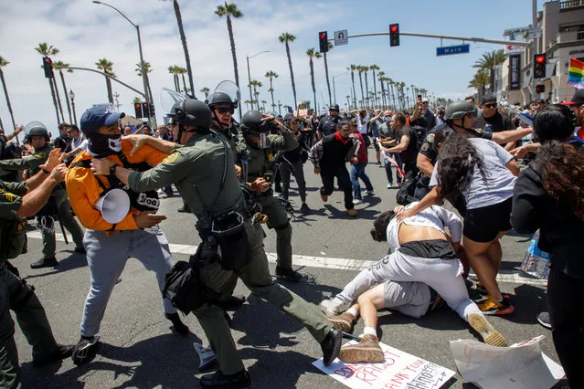 Black Lives Matter protesters brawl with supporters of US President Donald Trump as police try to break up the clashes during a demonstration due to the police killing of George Floyd in Huntington Beach, California USA, 06 June 2020. Hundreds of anti-police brutality protesters blocking Pacific Coast Highway were met by dozens of Trump supporters opposing their presence in the community. (Photo by Eugene García/EPA/EFE)