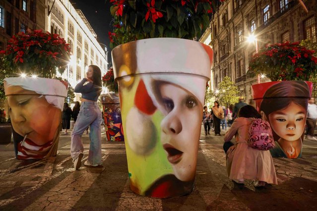 People visit Christmas lights and decorations at Zocalo square in Mexico City, Mexico on December 19, 2023. (Photo by Rodrigo Oropeza/AFP Photo)