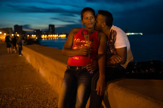 As the sun sets on the Malecon in Havana on Friday January 23, 2015, Yurania Fabie, 31, left, is embraced by her boyfriend, Eduardo Fromata, 25. (Photo by Sarah L. Voisin/The Washington Post)