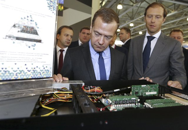 Russian Prime Minister Dmitry Medvedev (L) visits the international specialized exhibition “Import substitution”, with Minister of Industry and Trade Denis Manturov (R) seen nearby, outside Moscow, Russia, September 15, 2015. (Photo by Dmitry Astakhov/Reuters/RIA Novosti)