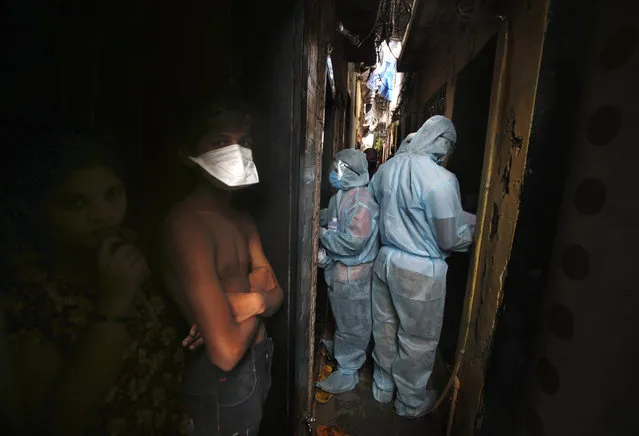Indian health workers wearing personal protective equipment perform door to door check up during a check up camp at a slum in Mumbai, India, Wednesday, June 17, 2020. India is the fourth hardest-hit country by the COVID-19 pandemic in the world after the U.S., Russia and Brazil. (Photo by Rafiq Maqbool/AP Photo)