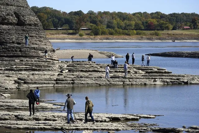 People walk to Tower Rock, an attraction normally surrounded by the Mississippi River and only accessible by boat, Wednesday, October 19, 2022, in Perry County, Mo. Foot traffic to the rock formation has been made possible because of near record low water levels along the river. (Photo by Jeff Roberson/AP Photo)