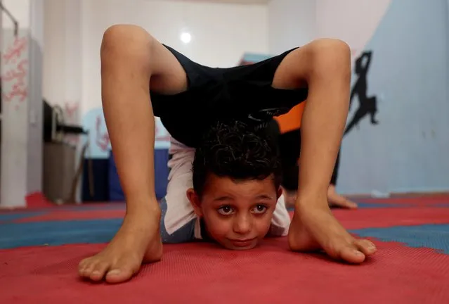 A Palestinian boy performs during a yoga and flexibility class on International Yoga Day amid the coronavirus disease (COVID-19) crisis, in a club in Gaza City on June 21, 2020. (Photo by Mohammed Salem/Reuters)