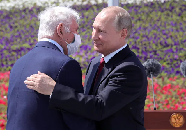 Russian President Vladimir Putin, right, congratulates the president of the Scientific Research Institute for Emergency Children's Surgery and Traumatology Leonid Roshal during a ceremony of handing Gold Stars medals to heroes of labor marking the Day of Russia holiday in Moscow, Russia, on Friday, June 12, 2020. The ceremony marked the first big public event Putin attended since announcing a nationwide lockdown more than two months ago. (Photo by Mikhail Klimentyev/Sputnik/Kremlin Pool Photo via AP Photo)