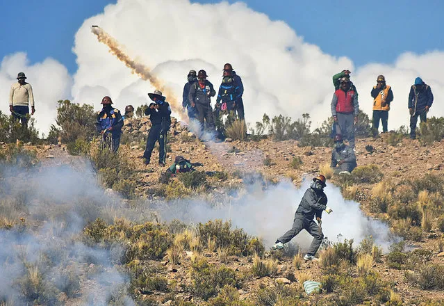 An independent miner returns a tear gas capsule during clashes with riot police during a protest against Bolivia's President Evo Morales' government policies, in Panduro south of La Paz, Bolivia, August 25, 2016. (Photo by Reuters/APG Agency)