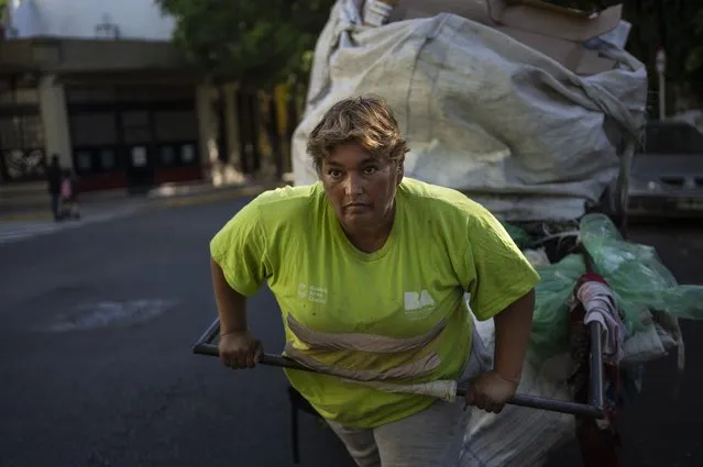 Noemi del Valle pushes a cart of recyclable items in Buenos Aires, Argentina, Thursday, November 10, 2022. Noemi, 56, said she leaves home at 3am to walk the capital for four hours and collect recyclable items to sell, earning about $150 dollars a month. (Photo by Rodrigo Abd/AP Photo)