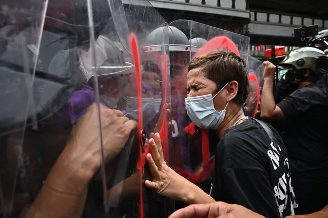 A protester pushes against riot police during a demonstration near the site of the Asia-Pacific Economic Cooperation (APEC) summit in Bangkok, Thailand on November 17, 2022. (Photo by Lillian Suwanrumpha/AFP Photo)