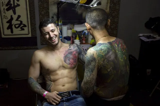 A man laughs as he has a tattoo during the International London Tattoo Convention in east London, Britain September 26, 2015. (Photo by Neil Hall/Reuters)