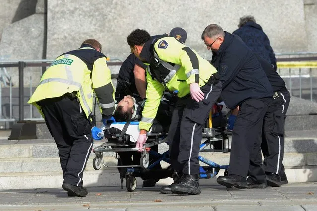 Paramedics and police wheel away a shooting victim at the National War Memorial near Parliament Hill in Ottawa Wednesday October 22, 2014.  (Photo by Adrian Wyld/AP Photo/The Canadian Press)