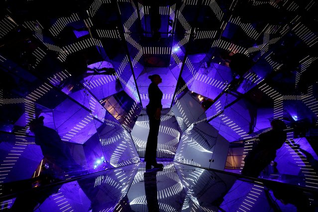 A staff member looks at Passengers by artist Guillaume Marmin during the installation of “Into the Light”, an immersive exhibition of light installations at the Grande Halle de la Villette in Paris, France, on April 4, 2025. (Photo by Benoit Tessier/Reuters)
