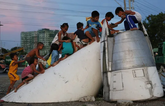 Filipino children play on part of a retired McDonnell Douglas DC-9 plane, which was placed on a vacant lot near their homes in suburban Paranaque city, south of Manila, Philippines, Sunday, September 6, 2015. The local government plans to build a public park on the lot, with the retired passenger jet as its main attraction. (Photo by Aaron Favila/AP Photo)