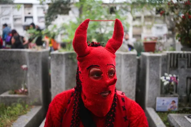 A member of the band called The Red Devils of Victor Jara takes a break during a demonstration commemorating the 43nd anniversary of Chile's 1973 military coup, inside the general cemetery in Santiago, Chile, Sunday, September 11, 2015. The coup toppled Chilean President Salvador Allende and began the military dictatorship of Gen. Augusto Pinochet. Jara, who was a Chilean teacher, theatre director, poet, singer-songwriter, and political activist, was arrested, tortured under interrogation and ultimately shot dead by the regime. (Photo by Esteban Felix/AP Photo)