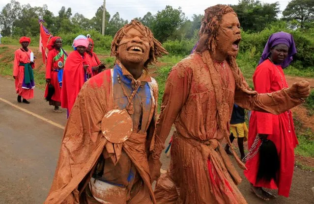 Believers of the Legio Maria of African Church Mission covered in mud, attend a procession as part of their Christmas Mass near Ugunja, in Siaya County, Kenya on December 25, 2022. (Photo by Thomas Mukoya/Reuters)
