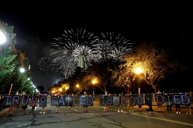 Donald Trump campaign fireworks explode behind the Washington Monument as demonstrators hold signs during a protest in Washington, U.S. August 27, 2020. (Photo by Andrew Kelly/Reuters)