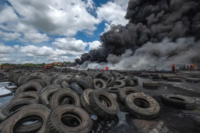 Firefighters try to extinguish fire at a out tire factory in Pekanbaru, Riau Province, Indonesia, on August 18, 2020. No casualties were reported at this fire. (Photo by Afrianto Silalahi/NurPhoto via Getty Images)
