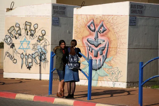 Schoolgirls stand next to bus stop bomb shelters in the southern city of Sderot, close to the Israeli border with the Gaza Strip, Israel January 8, 2018. (Photo by Amir Cohen/Reuters)