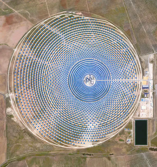 This Overview captures the Gemasolar Thermosolar Plant in Seville, Spain. The solar concentrator contains 2,650 heliostat mirrors that focus the sun's thermal energy to heat molten salt flowing through a 140-metre-tall (460-foot) central tower. The molten salt then circulates from the tower to a storage tank, where it is used to produce steam and generate electricity. In total, the facility displaces approximately 30,000 tonnes of carbon dioxide emissions every year. (Photo by Benjamin Grant/Penguin Random House)
